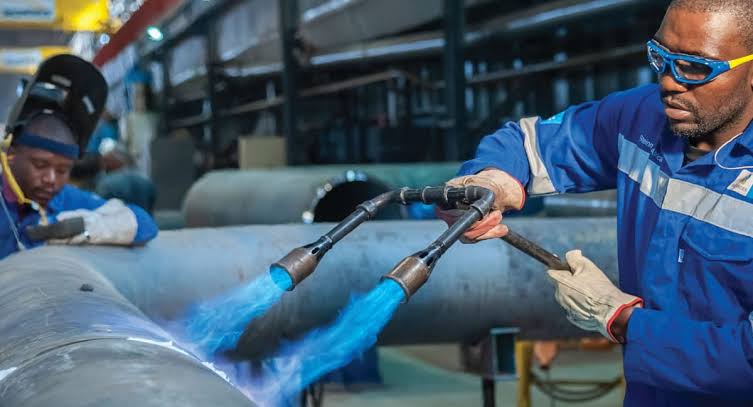 DOUBLE.M CORPS artisans preheating a heavy-wall pipe spool in the fabrication workshop